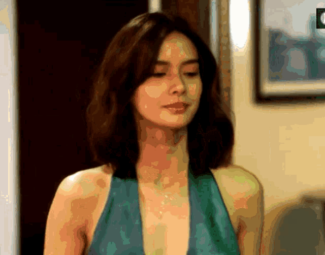 a woman in a green dress is standing in a room