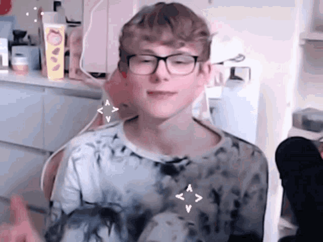 a boy wearing glasses and a tie dye shirt