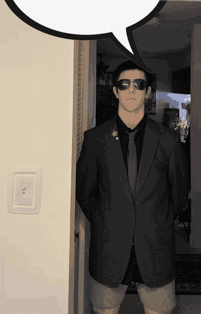 a man in a suit and tie is standing in a doorway