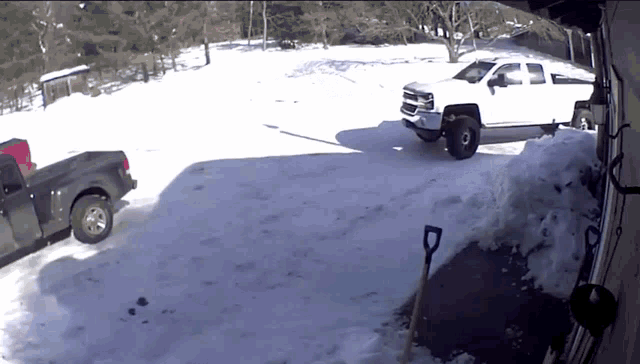 a white truck is parked next to a black truck