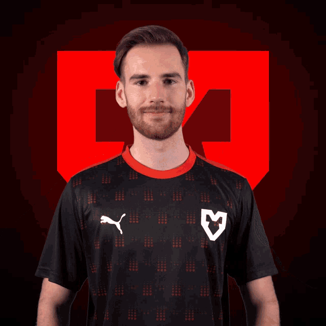 a man wearing a black puma shirt with a white heart on the front
