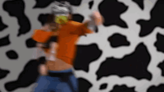 a blurry picture of a person standing in front of a cow print wall .