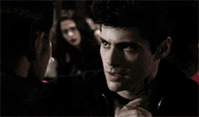 a man and woman are kissing in a dark room