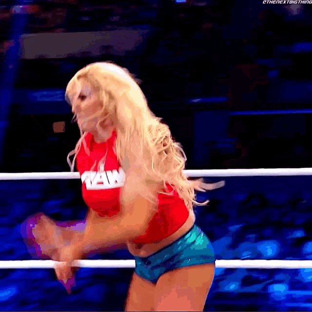 a woman is standing in a wrestling ring wearing a red shirt that says new york