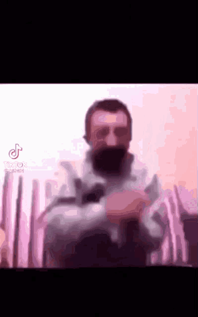 a man with a beard and sunglasses is making a funny face
