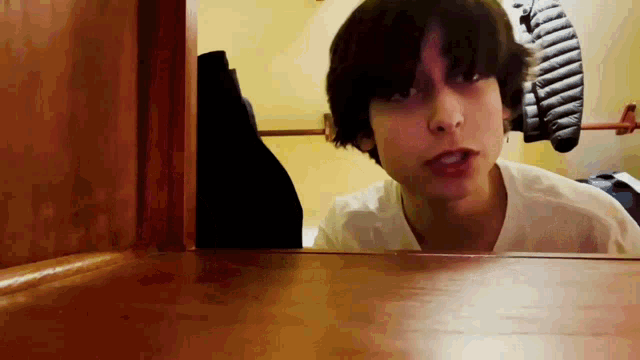 a young man is standing in a closet and looking at the camera