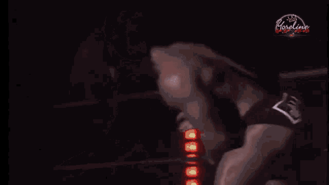 a muscular man without a shirt is standing in the dark .