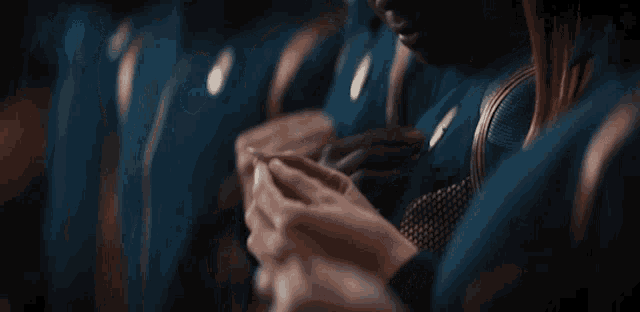 a group of people are sitting in a row and one of them is holding a cell phone