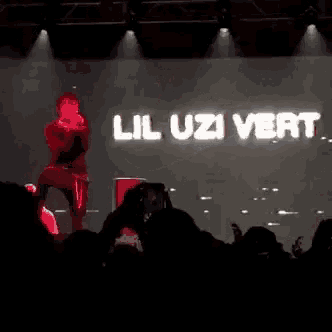 a man is kneeling on a stage in front of a large screen with a nike logo on it .