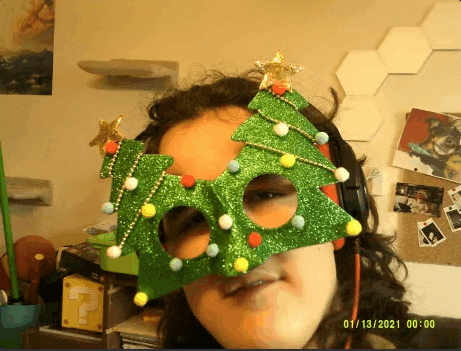 a woman wearing a christmas tree shaped mask takes a selfie