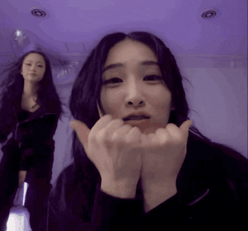 two women are making funny faces with their hands on their chins