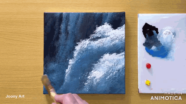 a painting of waves is being painted by a person named joony art