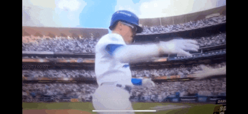 a man in a dodgers uniform is dancing in a stadium during a baseball game