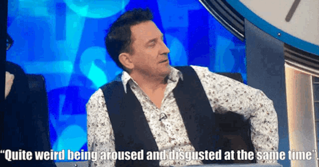 a man sitting in front of a clock says " quite weird being aroused and disgusted at the same time '