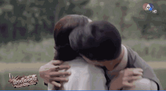 a man and woman hugging in front of a sign that says hd