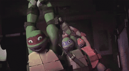 a group of teenage mutant ninja turtles are hanging upside down from a ceiling .