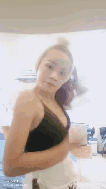 a woman in a black bra is taking a picture with a vivo y21