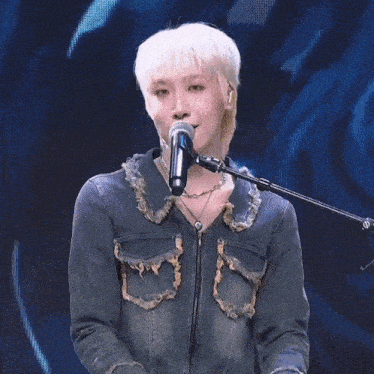 a woman is singing into a microphone with her eyes closed