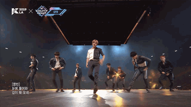 a group of men are dancing on a stage with a sign that says ' s9 ' on it