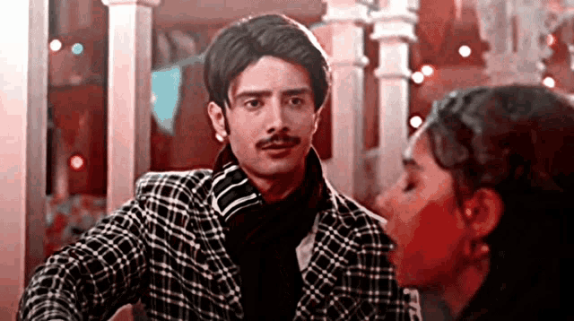 a man with a mustache is looking at a woman with red paint on her face