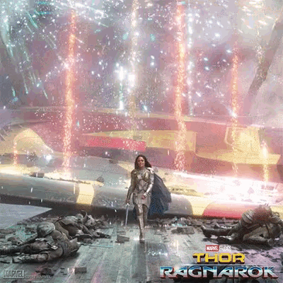 a poster for thor ragnarok shows a woman holding a sword in front of a fireworks display