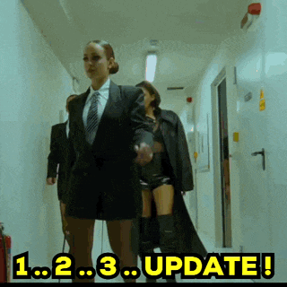 a woman in a suit and tie is walking down a hallway with the words update in the corner