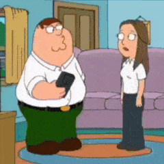 peter griffin is holding a cell phone while talking to a woman in a living room .
