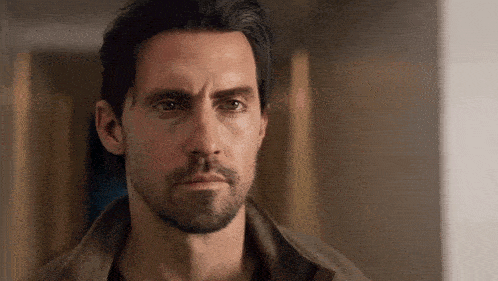 a man with a beard and long hair is looking at the camera