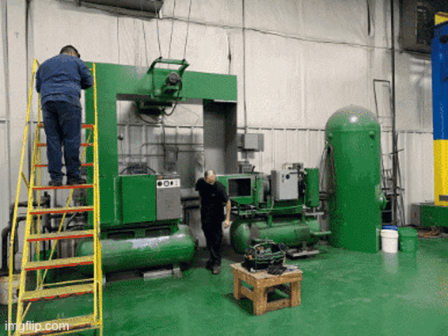 a man standing on a ladder in front of a green machine that says oem on it