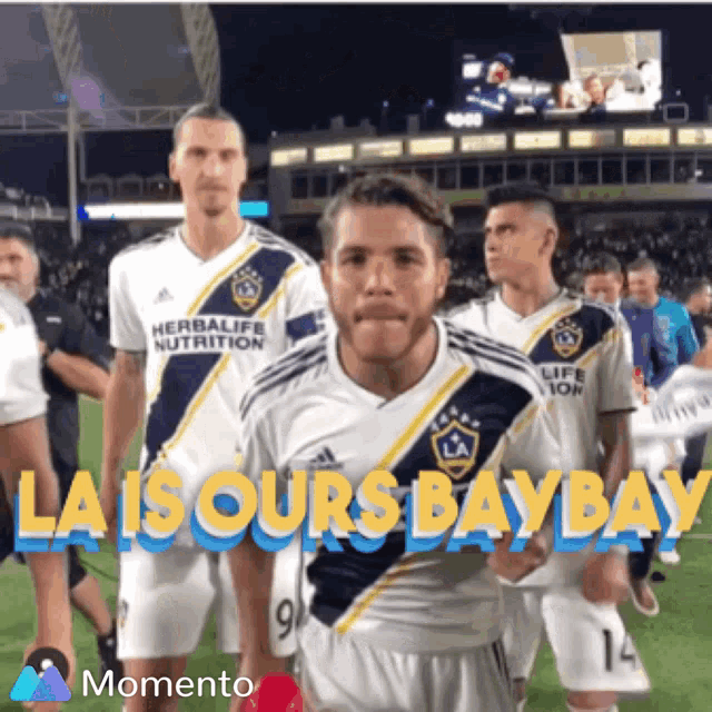 a group of soccer players standing on a field with the words la is ours bay bay