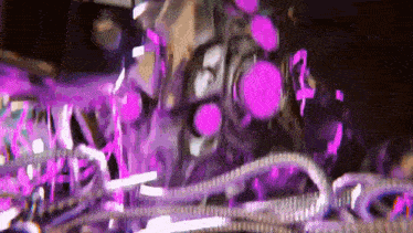 a close up of a machine with purple lights in the background