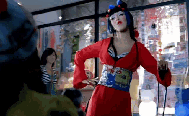 a woman in a red dress is dancing in a room