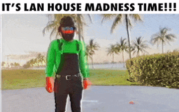 a man in overalls and a green shirt is standing in front of palm trees with the words it 's lan house madness time