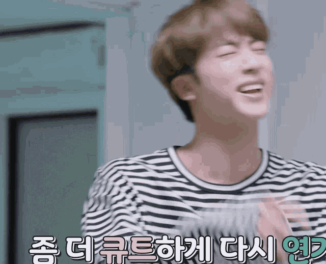 a man wearing a black and white striped shirt is laughing in a foreign language