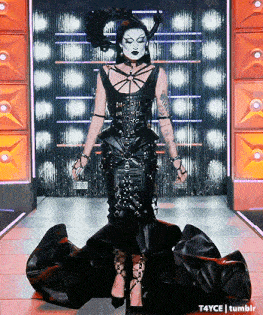 a woman in a black dress is standing on a stage