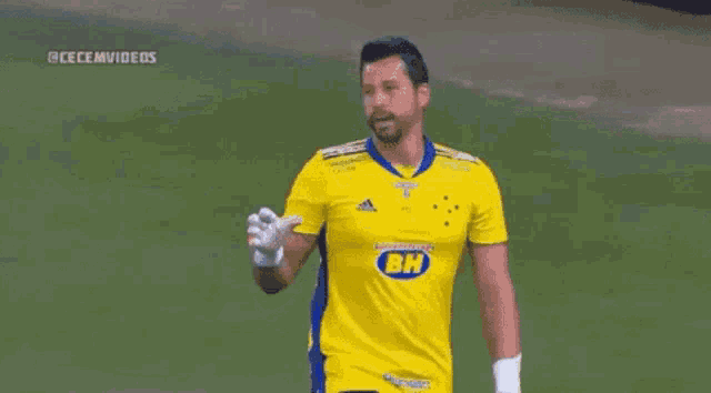 a man wearing a yellow shirt with bh on it