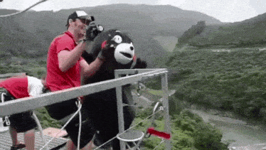 a man is taking a picture of a stuffed animal on a bungee jump .