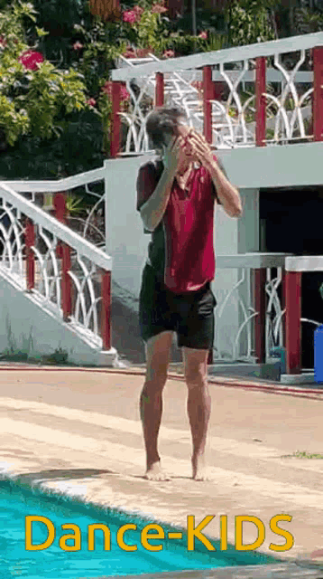 a man in a red shirt and black shorts is standing in front of a swimming pool with the words dance-kids on the bottom