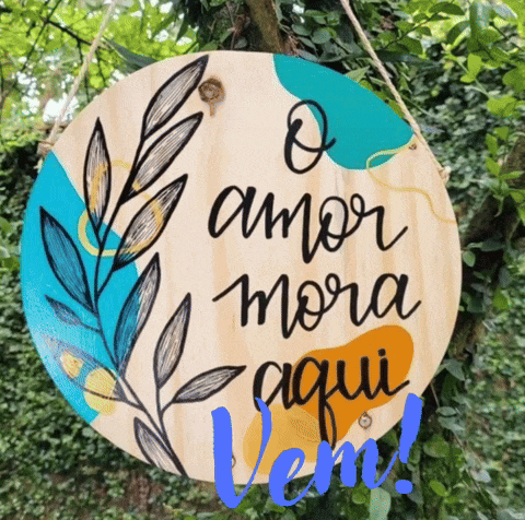 a sign that says o amor mora aqui is hanging from a tree