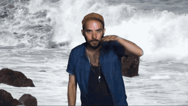 a man with a beard is standing on the beach