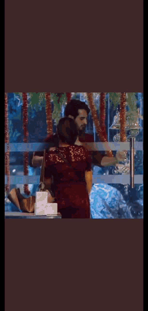 a man and woman are standing next to each other in front of a window