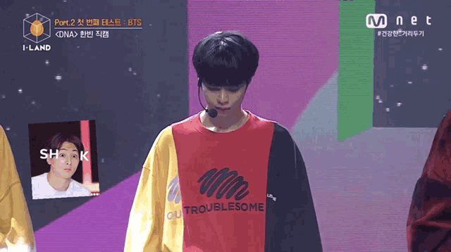 a man wearing a red yellow and black shirt that says outtroublesome