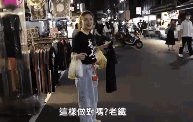 a woman in a black shirt is standing in front of a store that sells 190 shirts