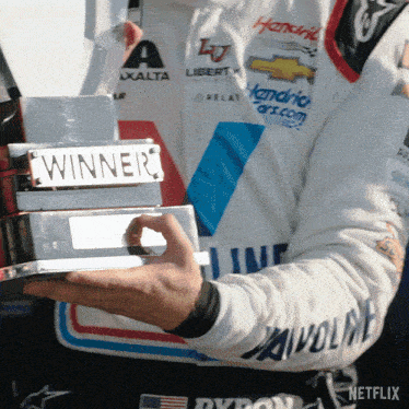 a man holding a trophy that says winner