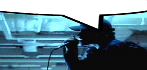 a man singing into a microphone with a speech bubble in the background