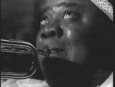 a black and white photo of a man playing a trumpet in a band .
