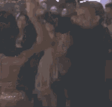 a man and a woman are dancing in a crowd of people at a party .