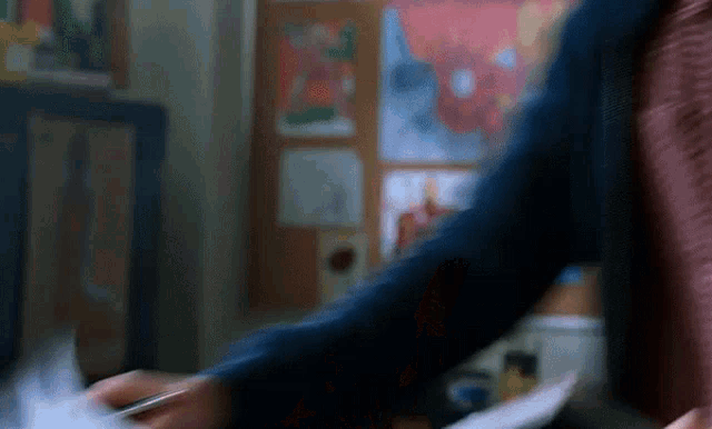 a person is holding a piece of paper in their hand in a room .