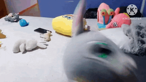 a bunch of stuffed animals are on a bed including a spongebob pillow
