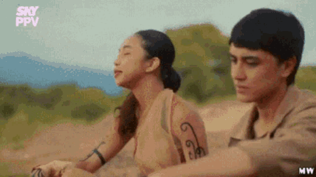 a man and a woman are sitting next to each other in a field with sky ppv written on the bottom